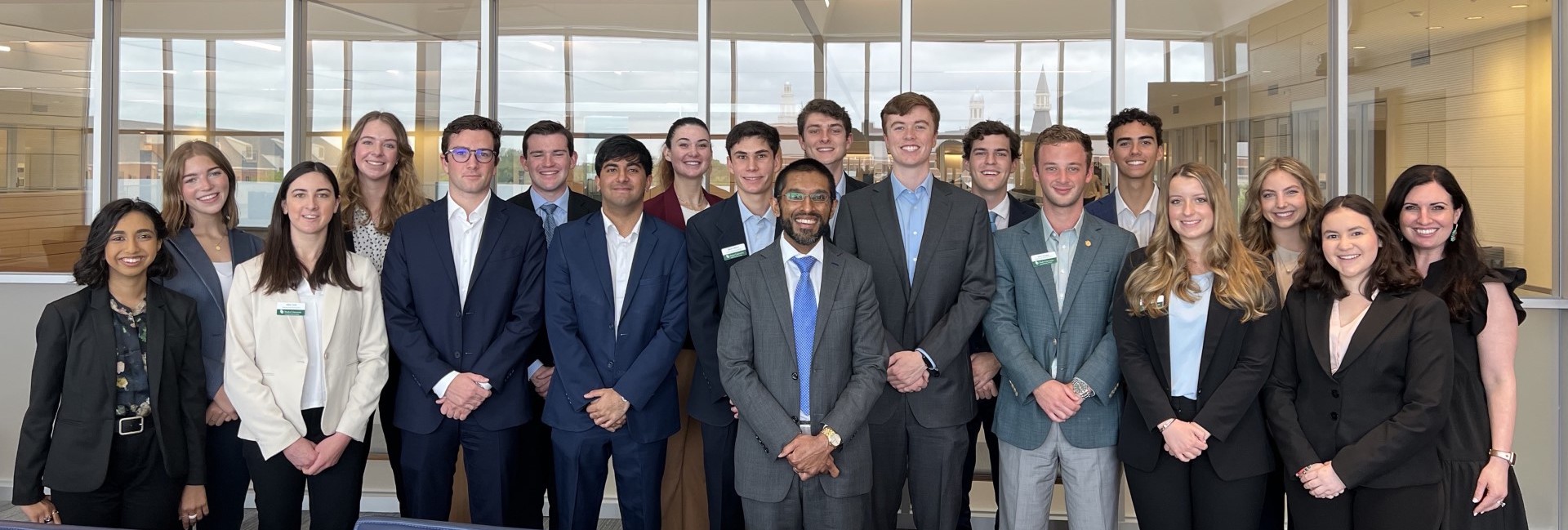 Group photo of several professionally-dressed students within the Hankamer Student Organization with Dean Sandeep Mazumder in the middle