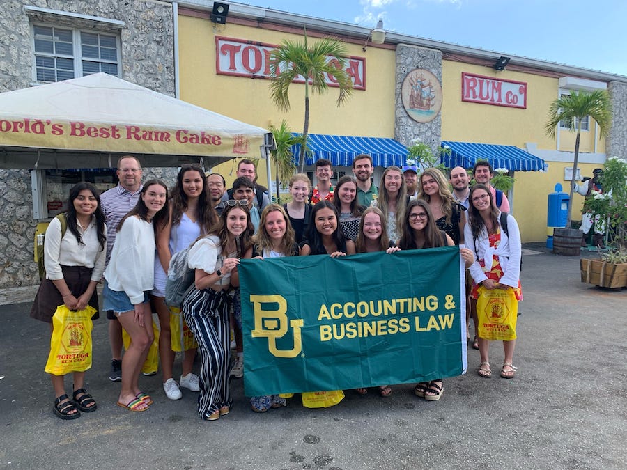 Group of Baylor Students in Cayman Islands holding a BU Accounting & Business Law flag