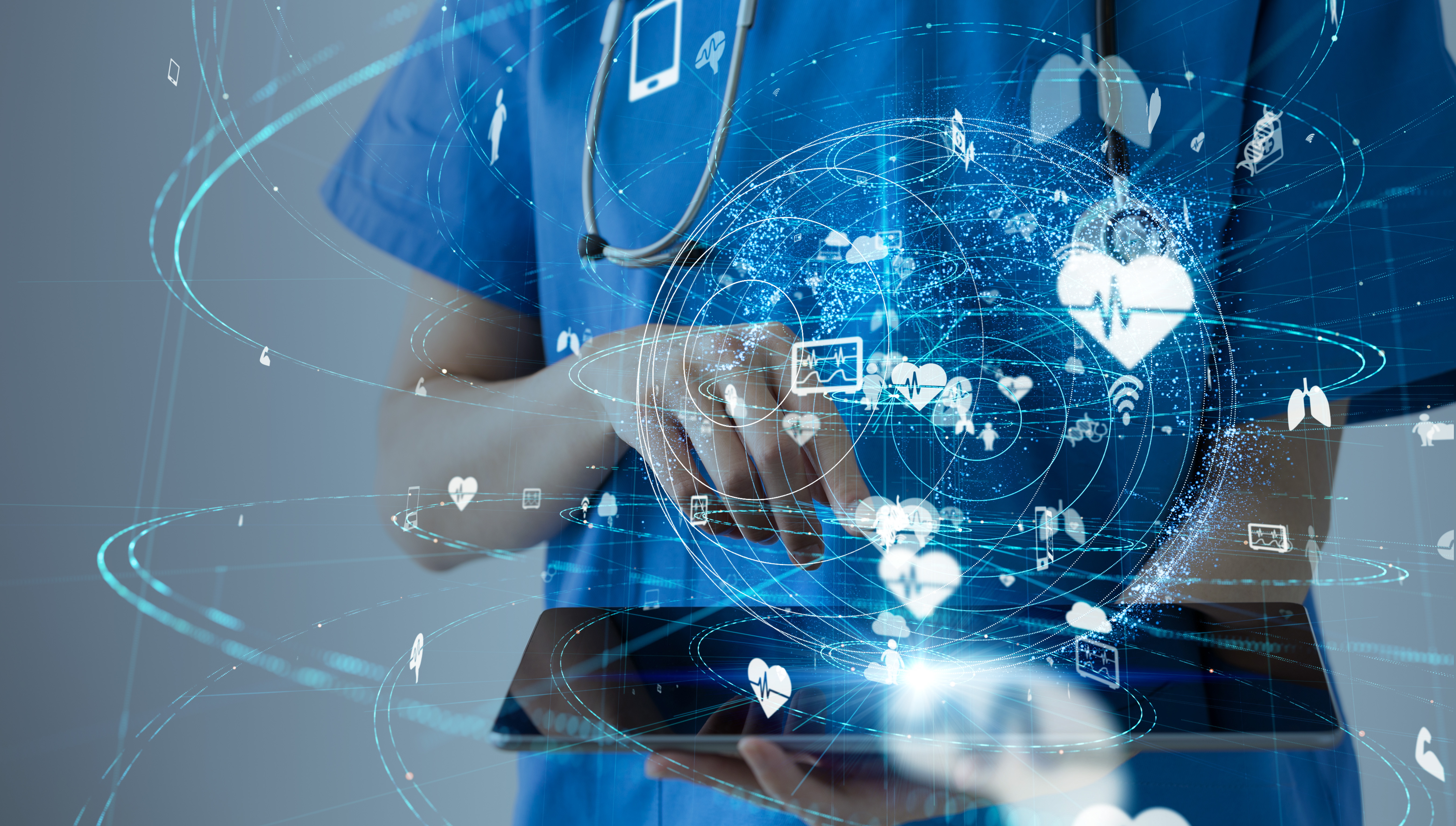 Nurse holding an iPad with holographic healthcare symbols emanating from it