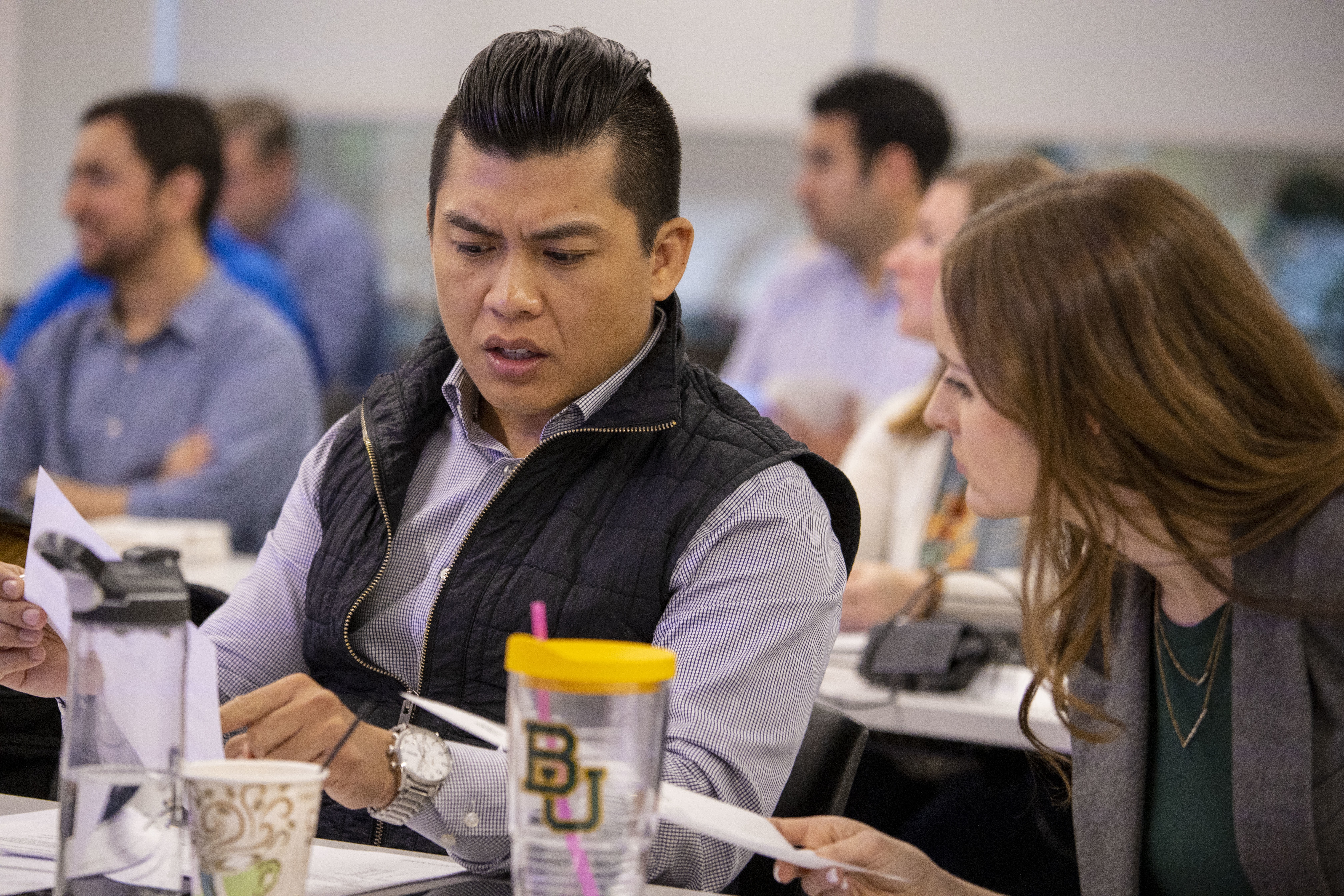 Baylor University MBA student talking with another student in the classroom environment