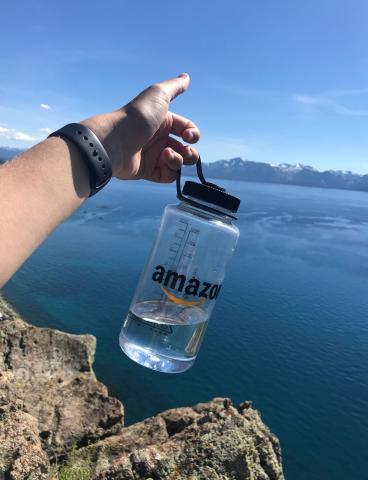 a person holding water bottle with amazon logo