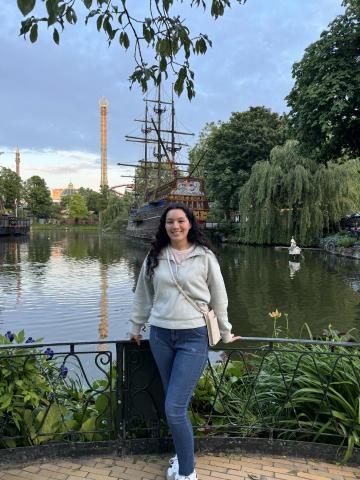 Carly Camacho standing in front of a Scandinavian background and a boat on a river