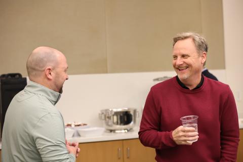 Two Baylor Business faculty members smiling and talking to each other