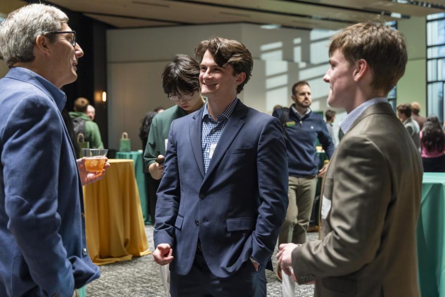Photo of business students networking with a business professional in a formal environment