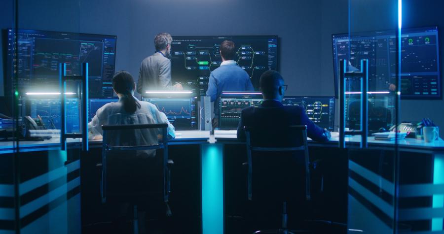 IT personnel in a low-lit room containing several computer monitors
