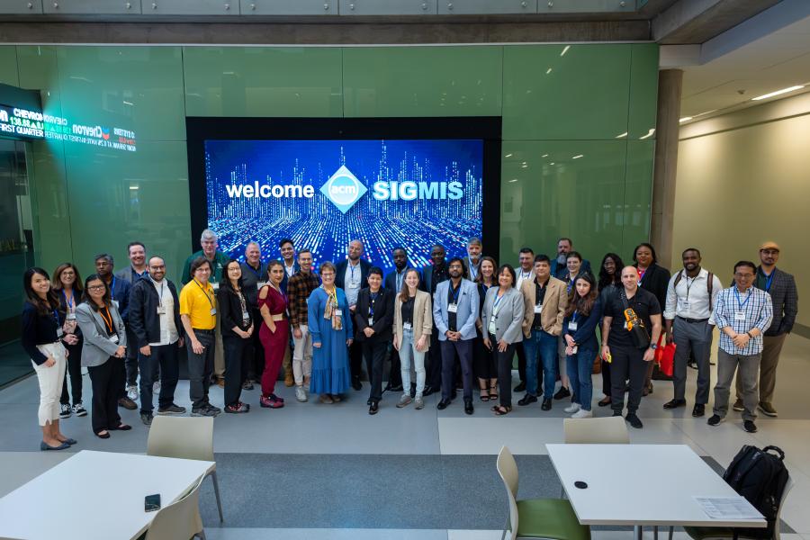 SIGMIS Conference group in front of screen in Foster atrium