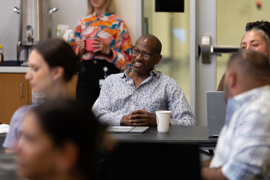 Business professional in an executive MBA classroom, smiling while seated at a table